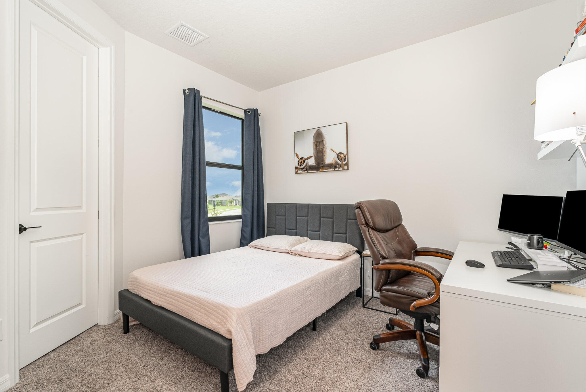 3179 Ribbon Grass Drive Melbourne, FL 32940 - Photo 31 of 52 a bedroom with a bed and a desk