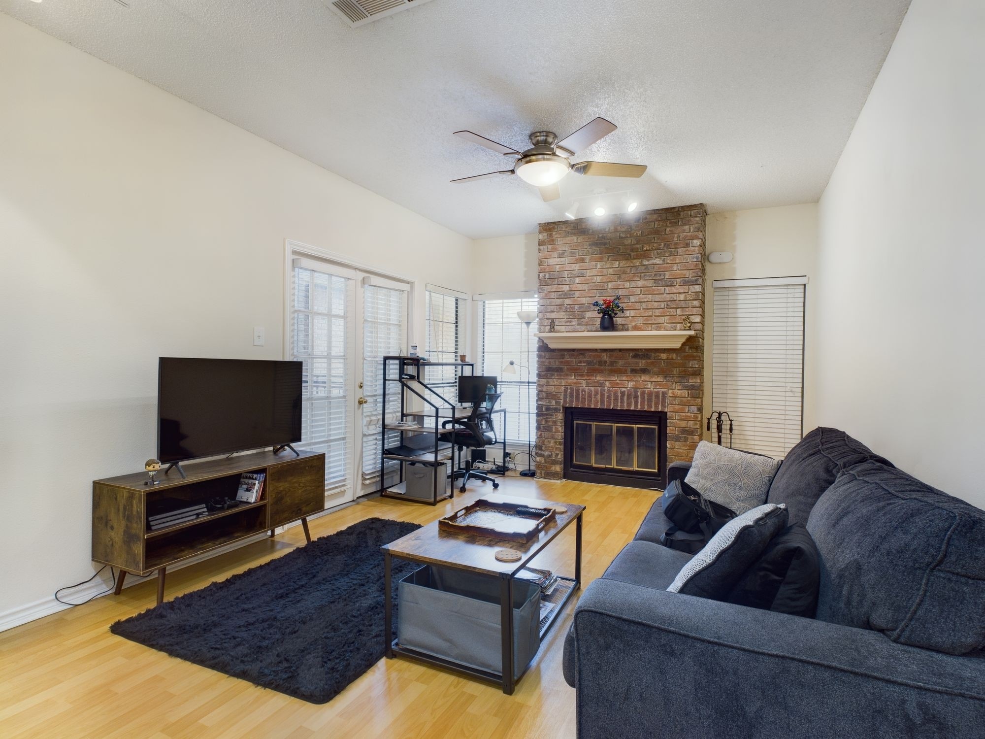 3001 Cedar Street, Unit 209 Austin, TX 78705 - Photo 4 of 17 a living room with furniture a flat screen tv and a fireplace
