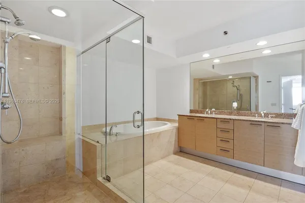 a bathroom with a granite countertop sink mirror and a bathtub