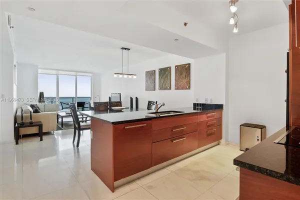 a large kitchen with kitchen island a large counter top space a sink stainless steel appliances and cabinets
