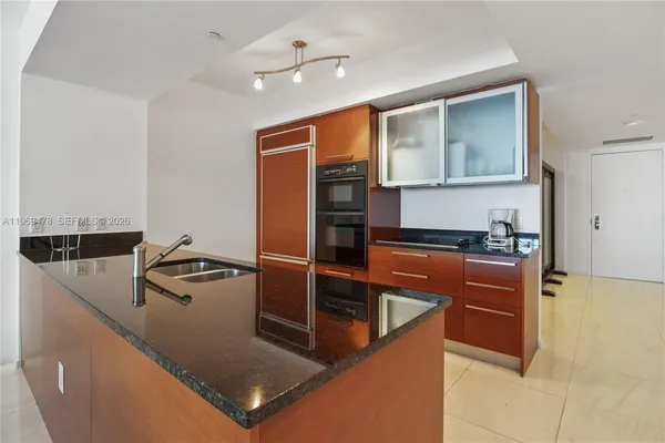a kitchen with stainless steel appliances granite countertop a sink and a refrigerator