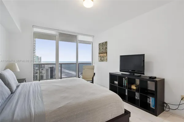 a bedroom with a bed and a flat screen tv