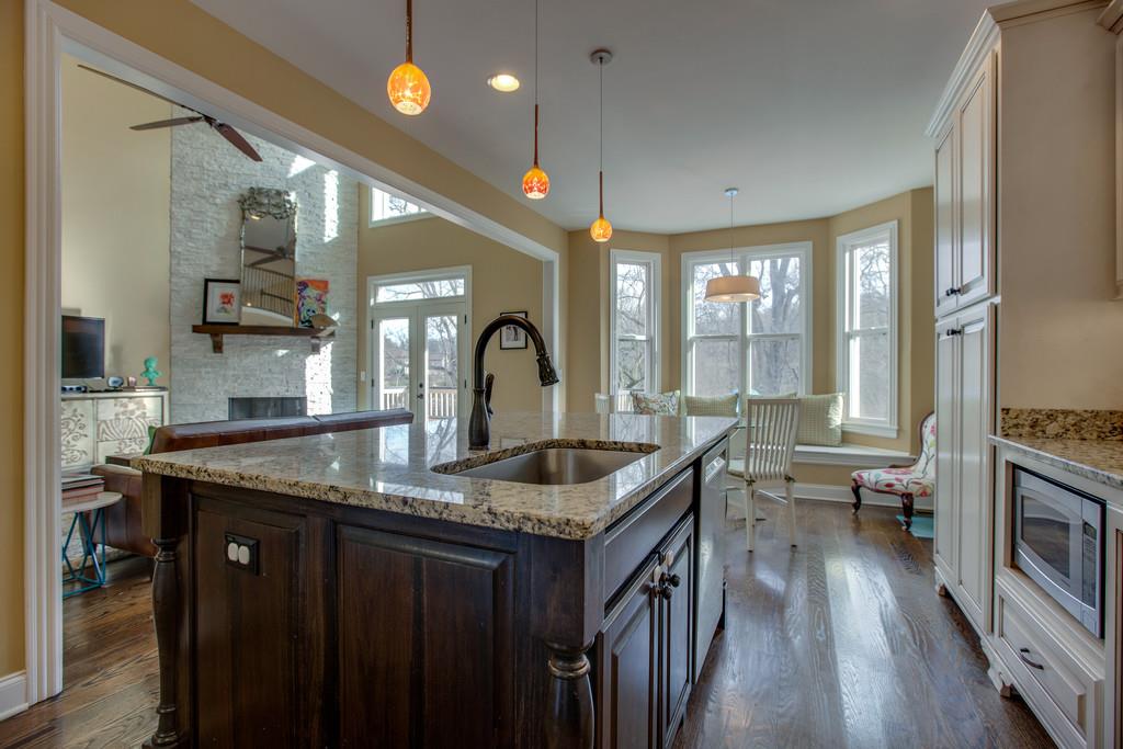 a kitchen with granite countertop a sink a counter top space appliances and cabinets