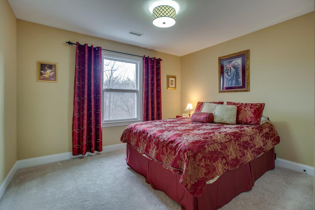4065 Clovercroft Road Franklin, TN 37067 - Photo 25 of 30 a bedroom with a bed and a chandelier