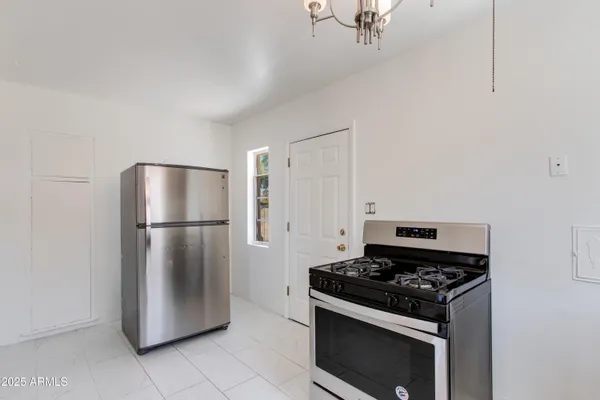 a kitchen with a stove and a refrigerator with white cabinets