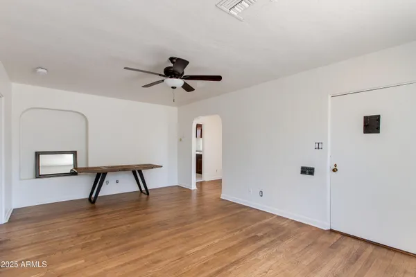 a view of empty room with wooden floor and window