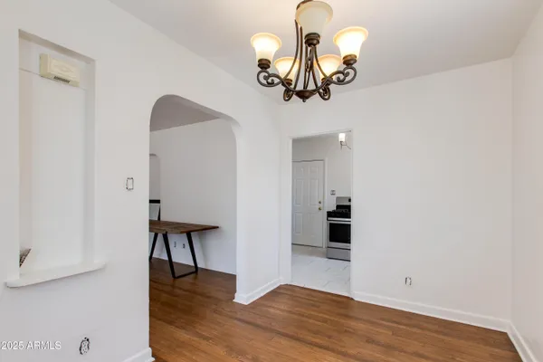 a view of a room with wooden floor and chandelier