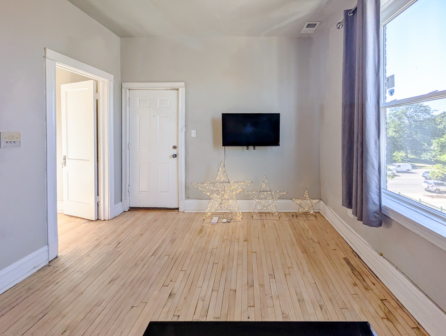 2838 West Roosevelt Road, Unit 3R Chicago, IL 60612 - Photo 11 of 23 a view of a livingroom with wooden floor and a flat screen tv