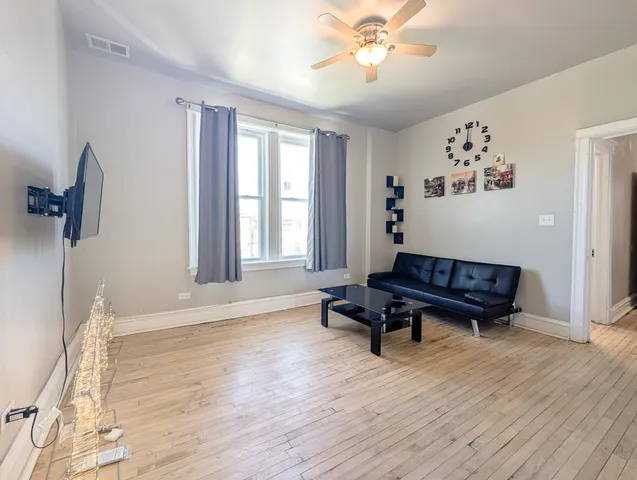 a living room with wooden floor and a window