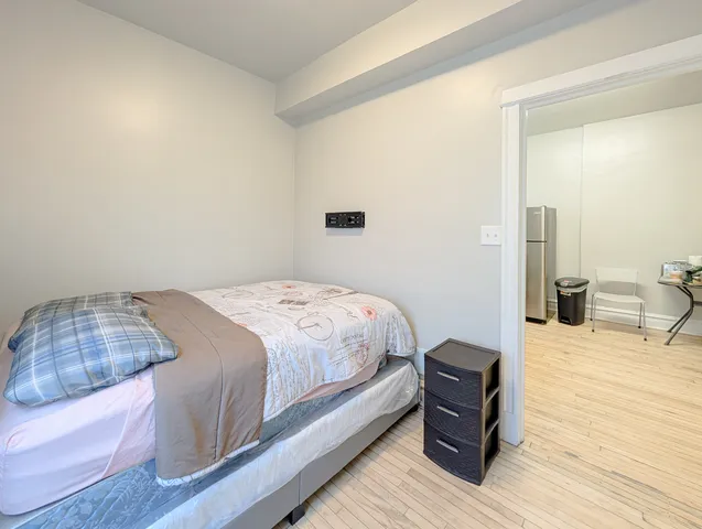 a bedroom with a bed and wooden floor