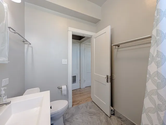 a bathroom with a granite countertop sink toilet and shower