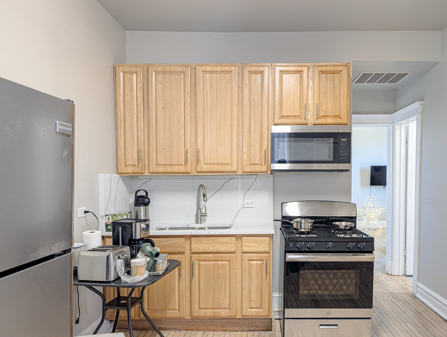 2838 West Roosevelt Road, Unit 3R Chicago, IL 60612 - Photo 2 of 23 a kitchen with stainless steel appliances granite countertop a stove a sink and a microwave