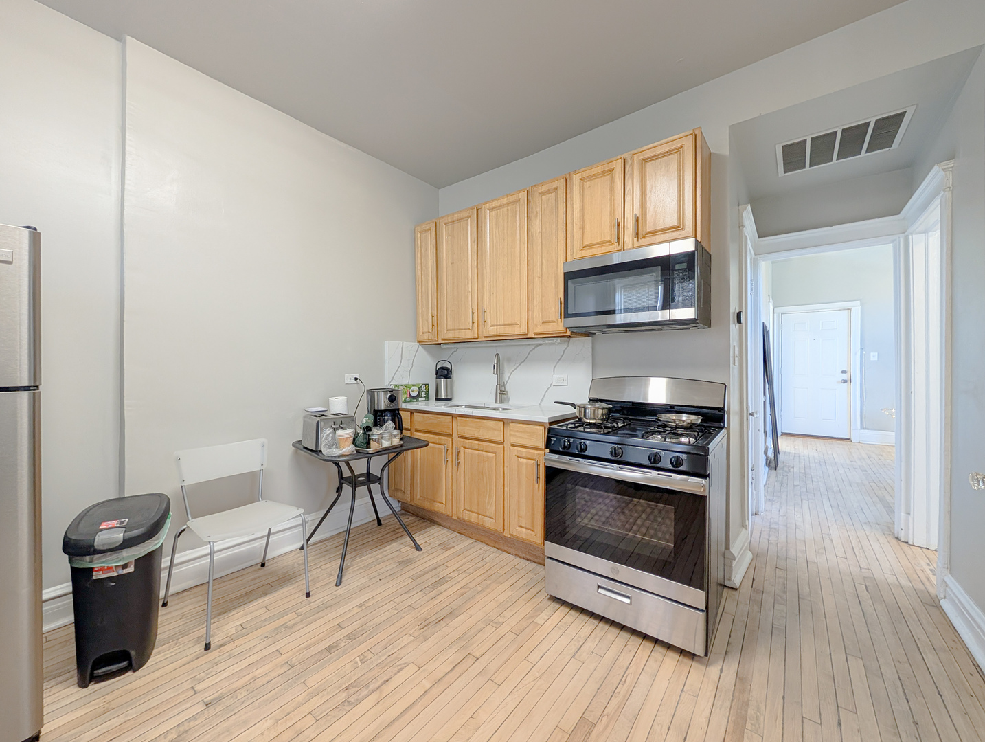 2838 West Roosevelt Road, Unit 3R Chicago, IL 60612 - Photo 4 of 23 a kitchen with stainless steel appliances a stove a sink and a microwave