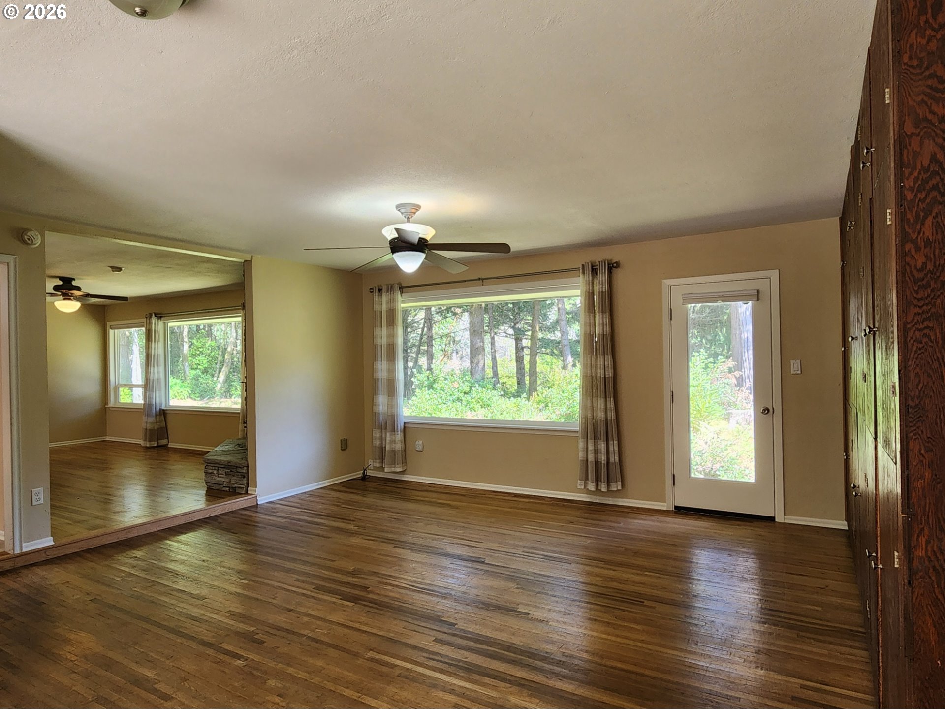 92504 Paradise Point Road Port Orford, OR 97465 - Photo 14 of 39 an empty room with wooden floor and windows