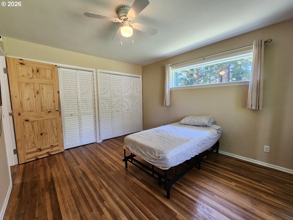 92504 Paradise Point Road Port Orford, OR 97465 - Photo 15 of 39 a spacious bedroom with a bed and a chandelier