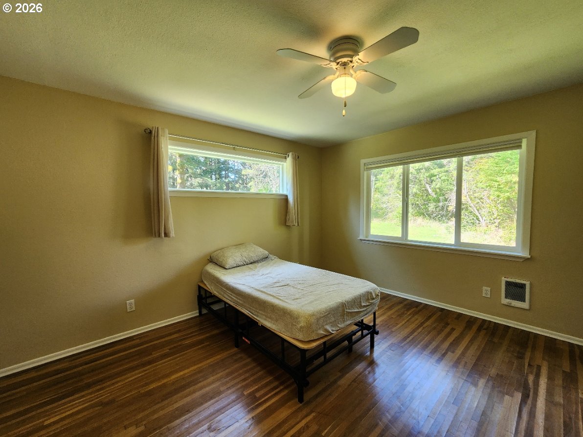 92504 Paradise Point Road Port Orford, OR 97465 - Photo 16 of 39 a bedroom with a bed table and window