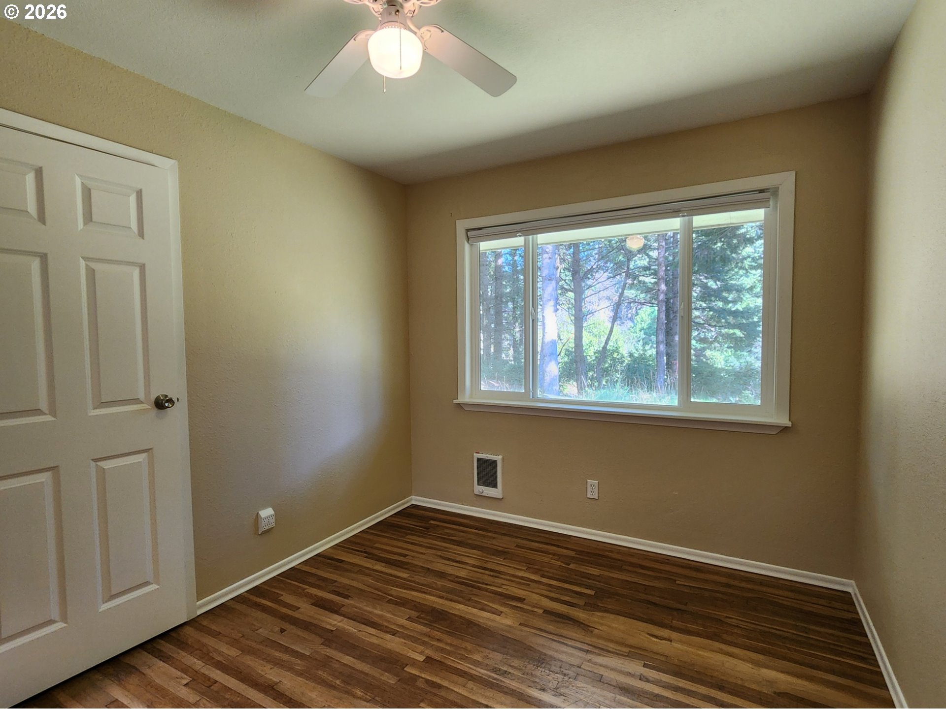 92504 Paradise Point Road Port Orford, OR 97465 - Photo 22 of 39 a view of an empty room with wooden floor and a window