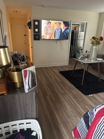 a view of a living room with a rug and wooden floor