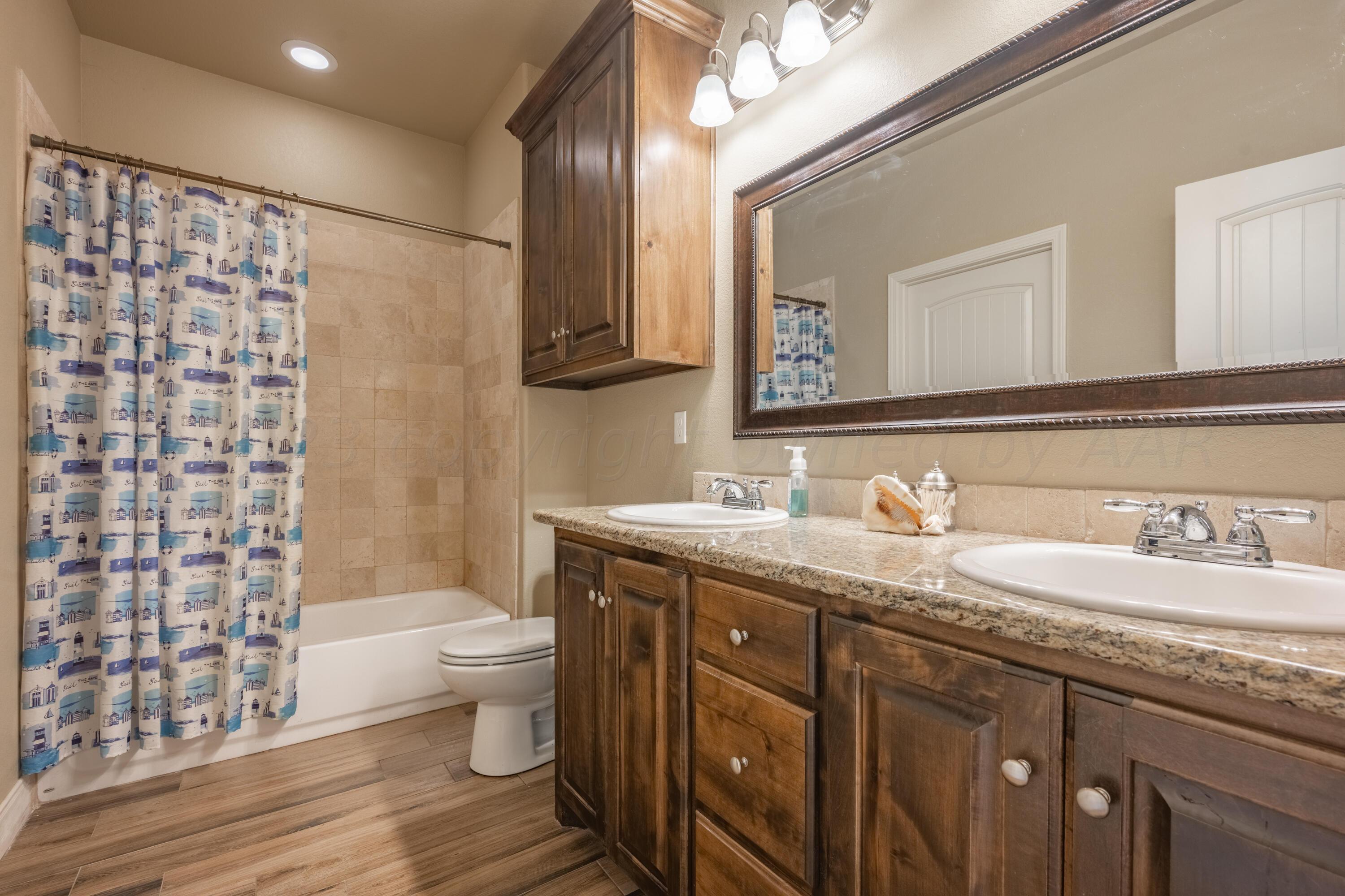 4910 Hicks Street Amarillo, TX 79118 - Photo 11 of 19 a bathroom with a granite countertop sink toilet and shower
