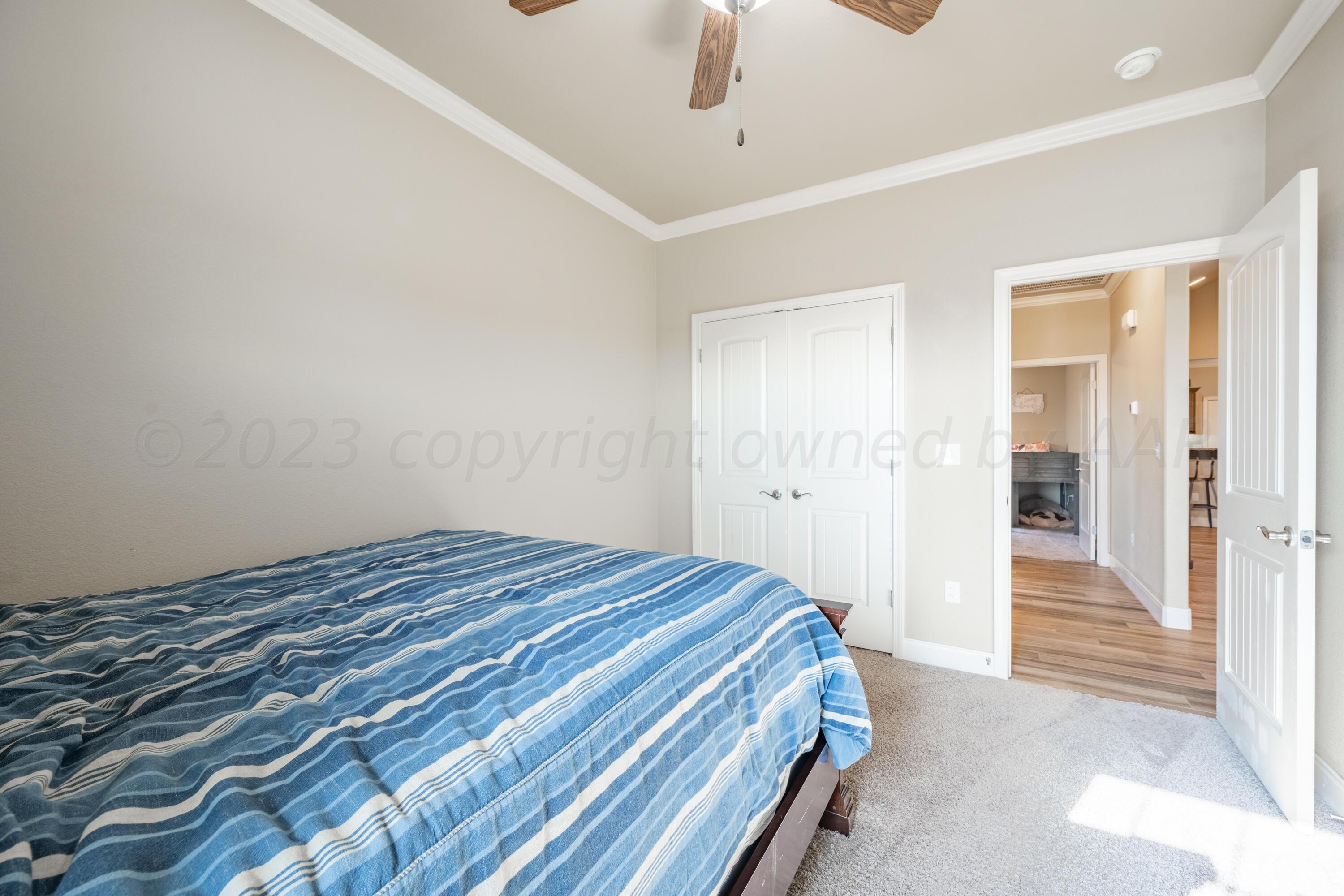 4910 Hicks Street Amarillo, TX 79118 - Photo 15 of 19 a room with a bed and a chandelier fan