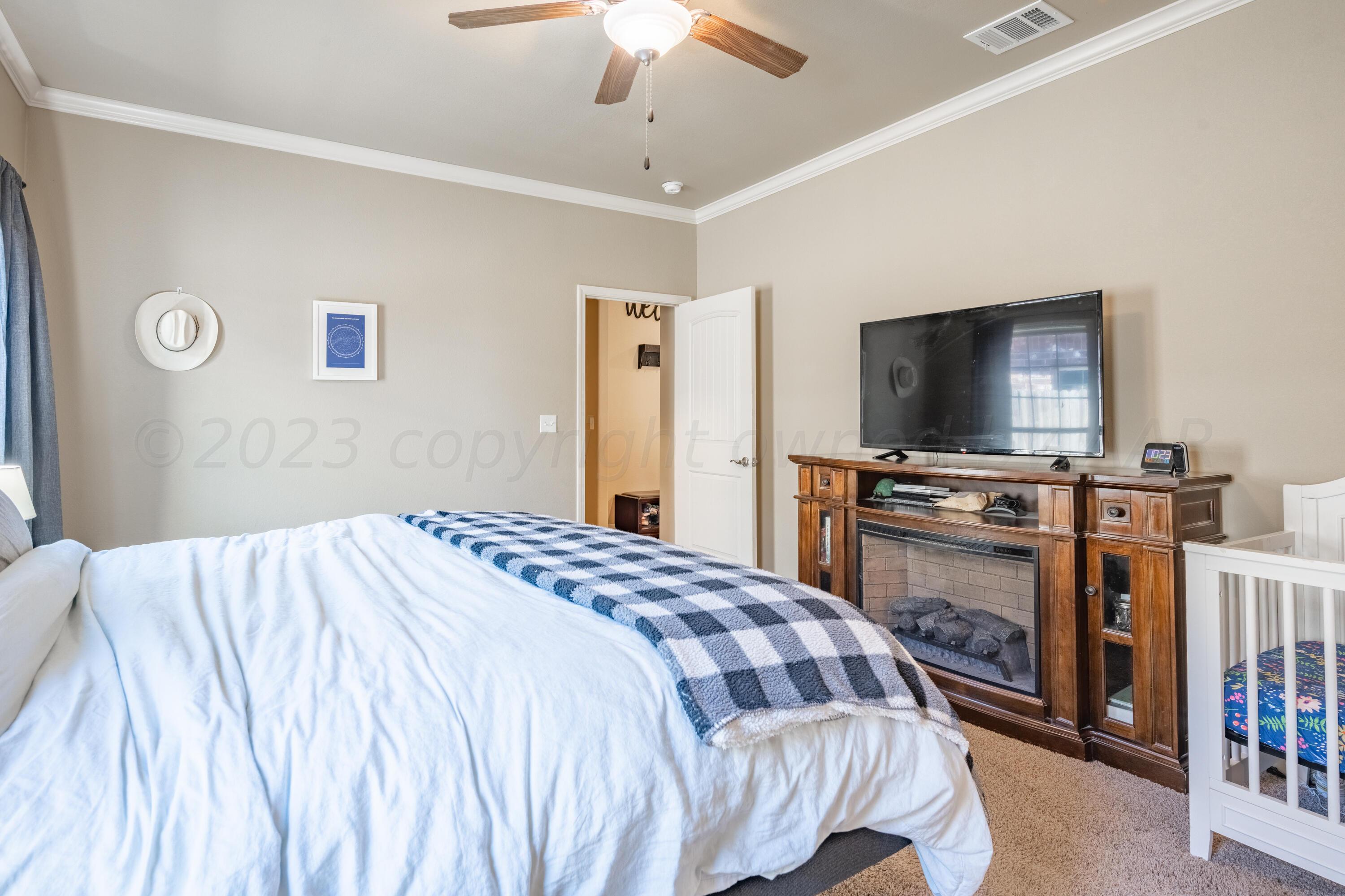 4910 Hicks Street Amarillo, TX 79118 - Photo 10 of 19 a bedroom with a bed and a flat screen tv