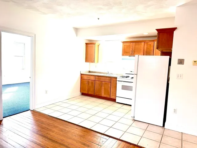 a kitchen with a refrigerator a stove top oven and a counter top space