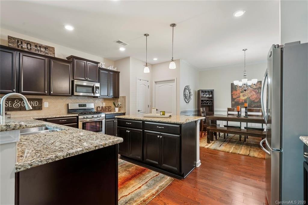 4303 Perth Road Indian Land, SC 29707 - Photo 14 of 32 a kitchen with stainless steel appliances granite countertop a sink a stove a refrigerator a center island and wooden floor