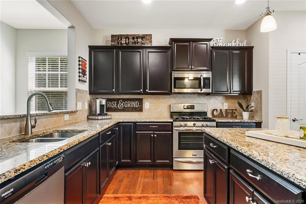 4303 Perth Road Indian Land, SC 29707 - Photo 18 of 32 a kitchen with stainless steel appliances granite countertop a stove microwave and sink