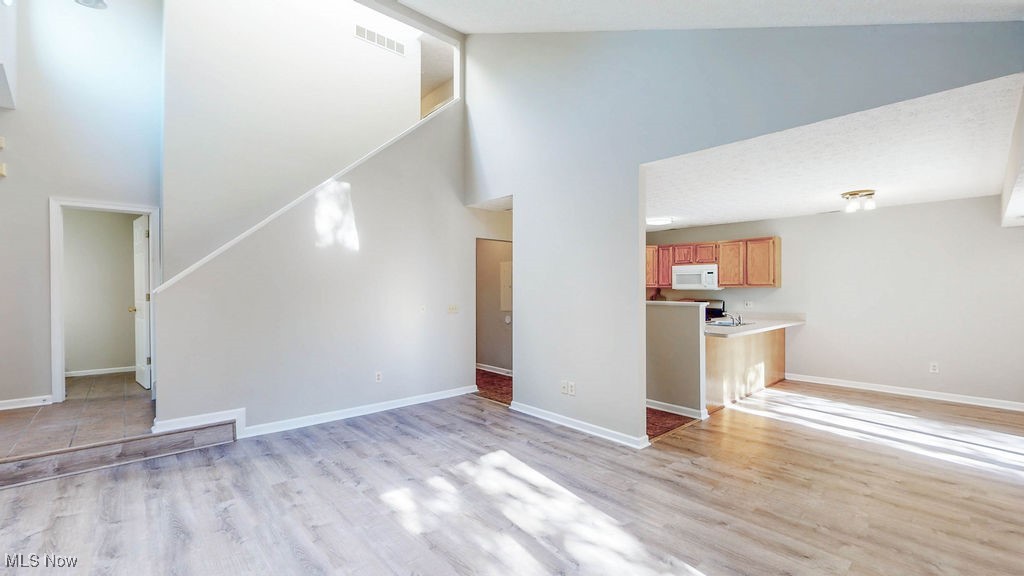 1426 Loop Road, Unit 1426 Kent, OH 44240 - Photo 7 of 40 Living room with high vaulted ceiling and light wood-style floors