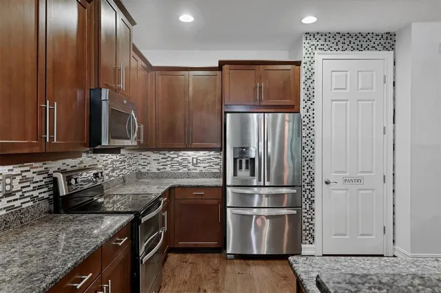 a kitchen with granite countertop stainless steel appliances and wooden cabinets