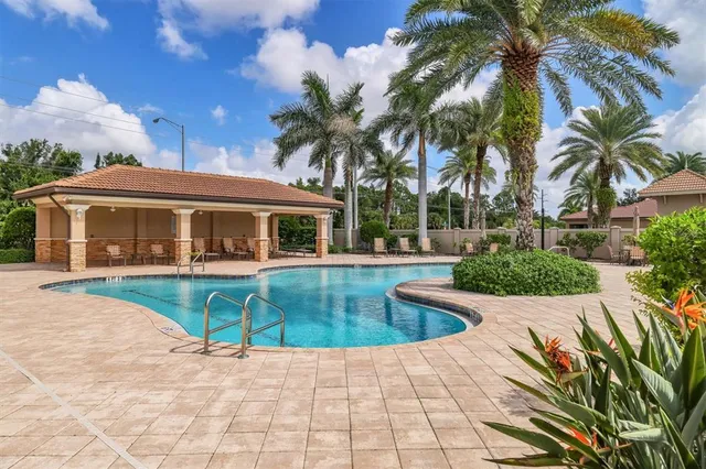 a view of house with swimming pool and sitting area