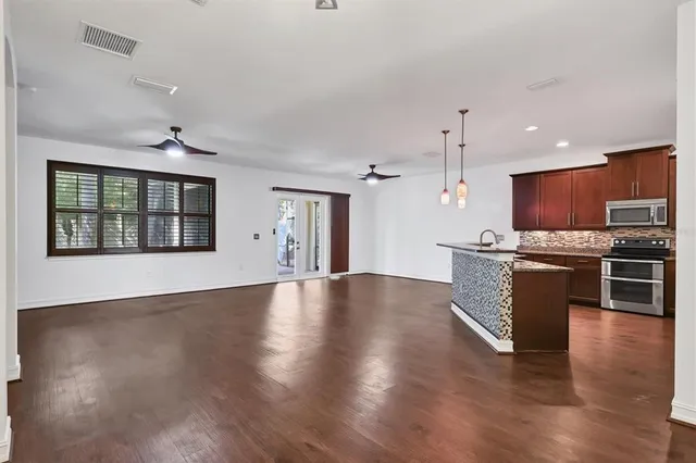 a large kitchen with stainless steel appliances granite countertop a stove top oven a refrigerator a sink with granite countertops and cabinets