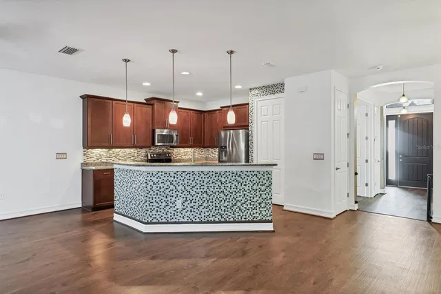 a view of kitchen with refrigerator cabinet and wooden floor