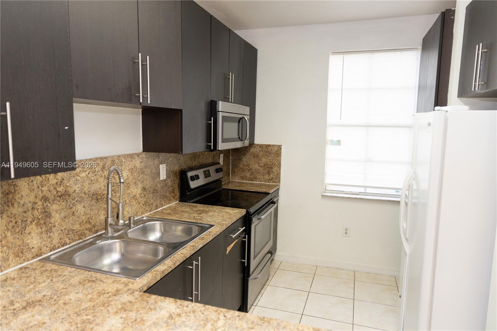761 Southeast 2nd Street Homestead, FL 33030 - Photo 2 of 17 a kitchen with stainless steel appliances granite countertop a sink stove and refrigerator