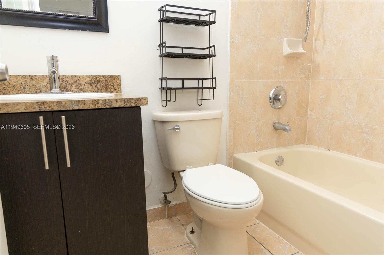 761 Southeast 2nd Street Homestead, FL 33030 - Photo 6 of 17 a bathroom with a granite countertop toilet a sink and bathtub