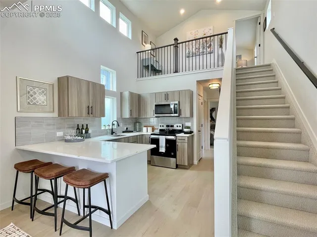 a kitchen with stainless steel appliances a stove a sink a microwave and refrigerator