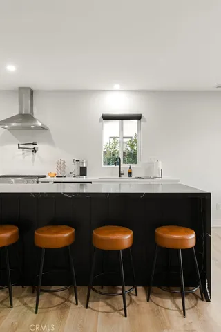 a kitchen with stainless steel appliances granite countertop a sink a stove a refrigerator cabinets and dining table