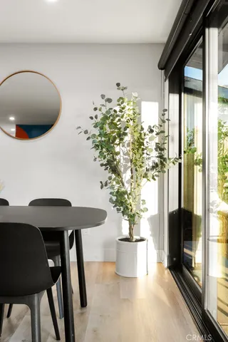 a kitchen with a dining table chairs and wooden floor