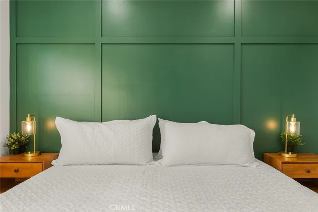 a bedroom with a bed and a lamp next to a window