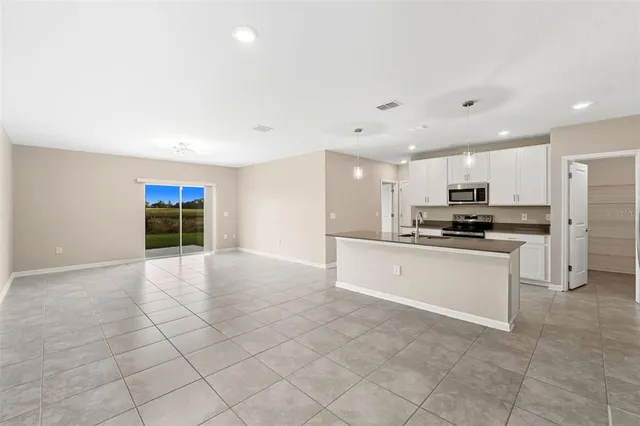 a kitchen with stainless steel appliances kitchen island granite countertop a refrigerator and a stove top oven