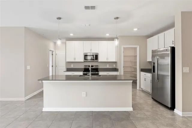 a kitchen with stainless steel appliances granite countertop a refrigerator and a stove