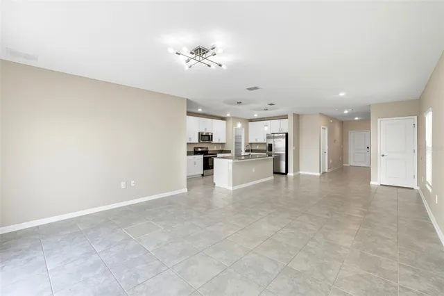 a view of a livingroom with kitchen and chandelier