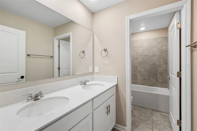 a bathroom with a shower sink and mirror