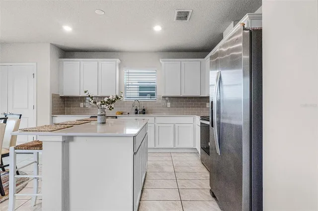 a kitchen with a sink a refrigerator and cabinets