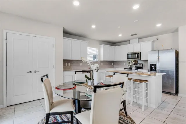 a kitchen with stainless steel appliances granite countertop a refrigerator and a stove top oven