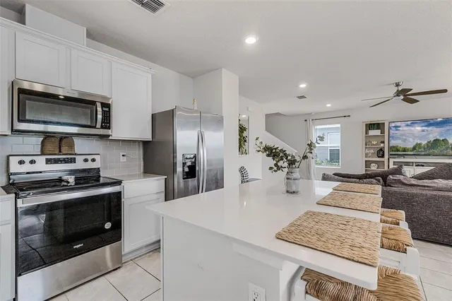 a kitchen with stainless steel appliances kitchen island granite countertop a refrigerator stove microwave and sink