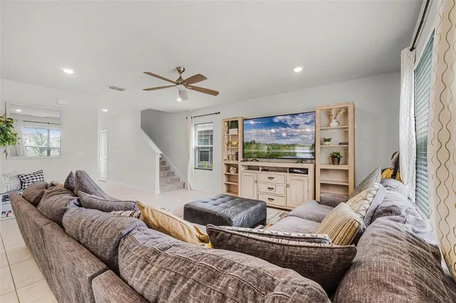 a living room with furniture ceiling fan and a rug