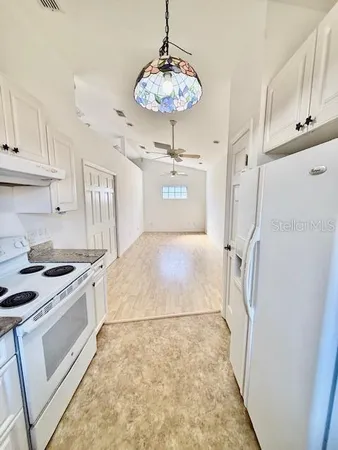 a kitchen with stainless steel appliances granite countertop a stove a sink and a white cabinets