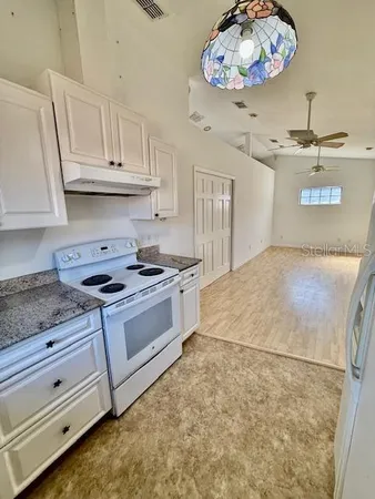 a kitchen with stainless steel appliances granite countertop a refrigerator a oven a sink with island and chairs