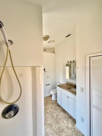 a bathroom with a granite countertop sink a toilet and vanity